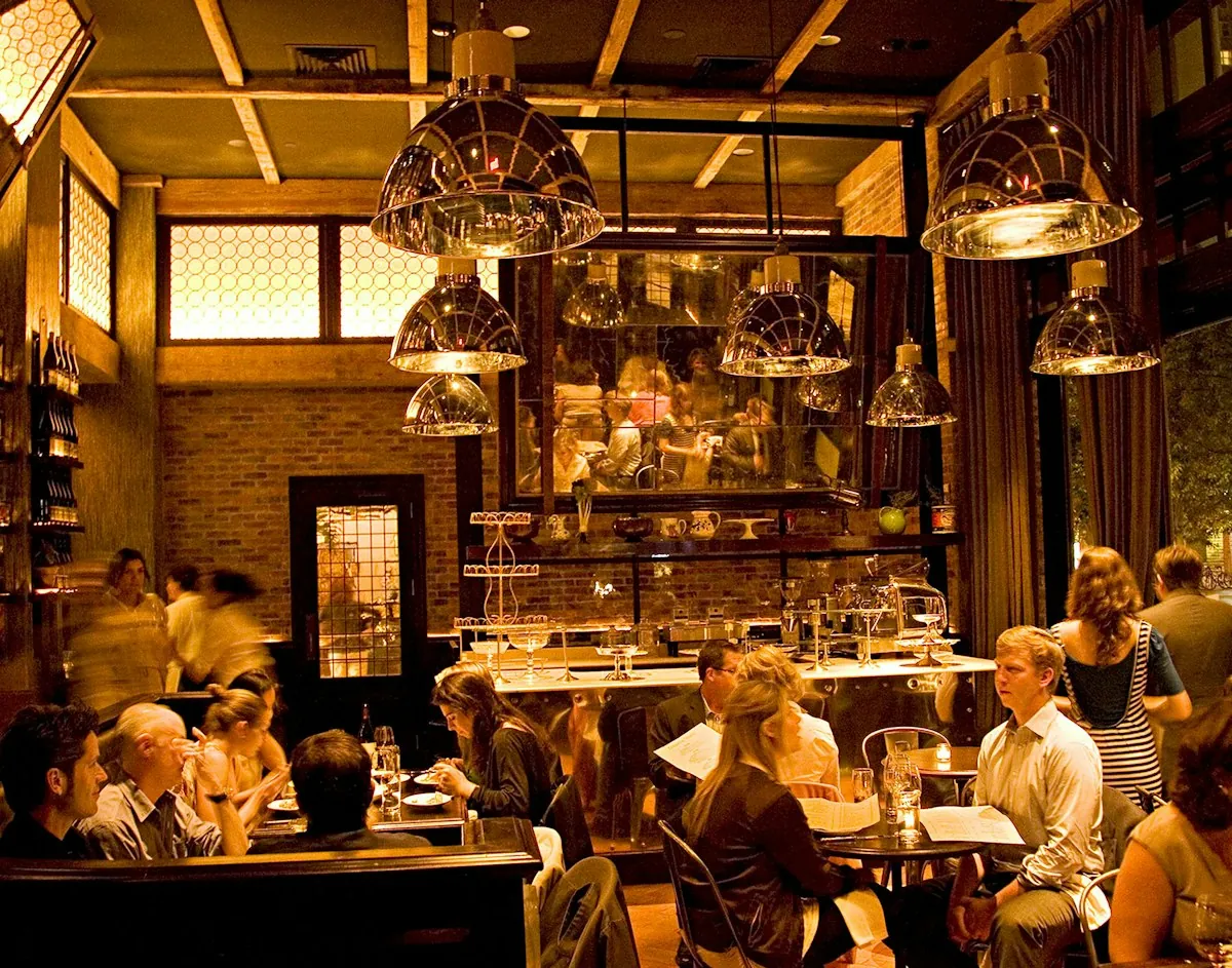 The dining room at Locanda Verde, lit by large pendant lamps